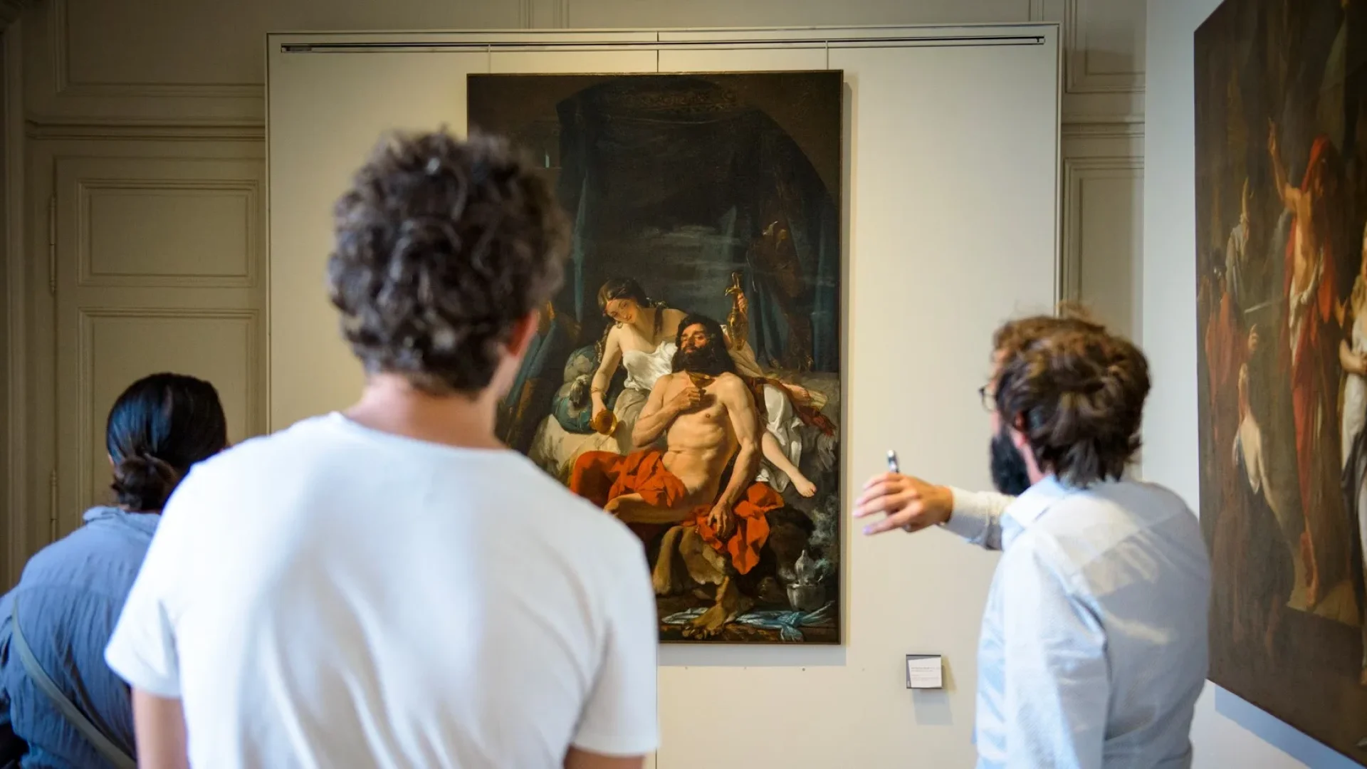 Groupe de visiteurs lors d'une visite guidée dans la galerie de peinture du Musée des Beaux-Arts de Limoges, observant des œuvres classiques.