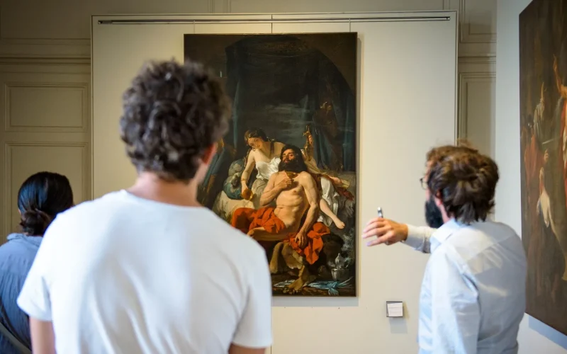 Groupe de visiteurs lors d'une visite guidée dans la galerie de peinture du Musée des Beaux-Arts de Limoges, observant des œuvres classiques.