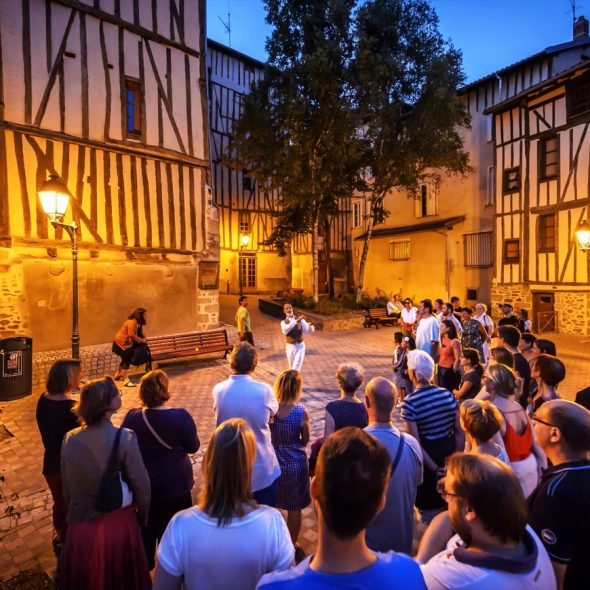 Groupe de touristes dans le quartier de la Boucherie de Limoges lors d'une visite guidée contée à la tombée de la nuit